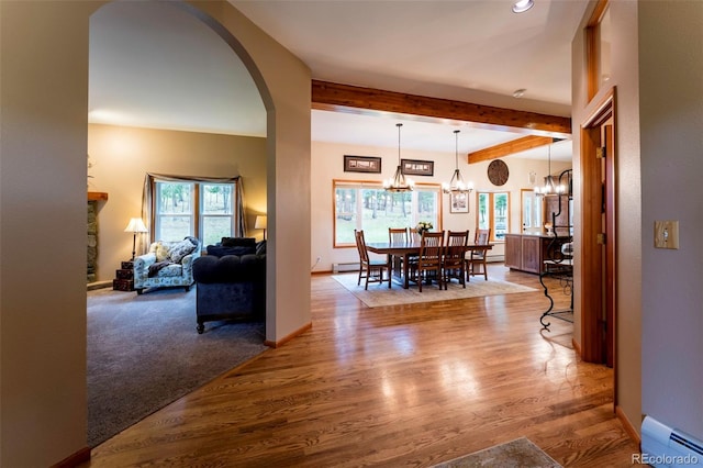 33 Sparrow Ct, Bailey, CO 80421 - dining area with a baseboard heating unit, a chandelier, healthy amount of natural light, arched walkways, and beam ceiling