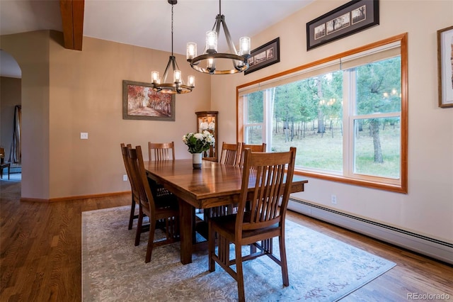 33 Sparrow Ct, Bailey, CO 80421 - dining area with baseboard heating, wood finished floors, a chandelier, arched walkways, and beam ceiling