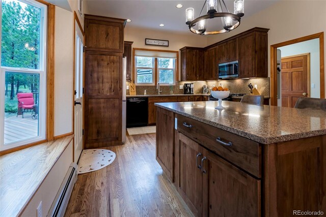 33 Sparrow Ct, Bailey, CO 80421 - kitchen featuring stainless steel microwave, dishwasher, light wood finished floors, a chandelier, and tasteful backsplash