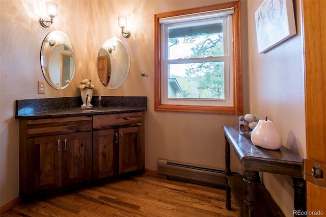 33 Sparrow Ct, Bailey, CO 80421 - bathroom featuring baseboard heating, vanity, and wood finished floors