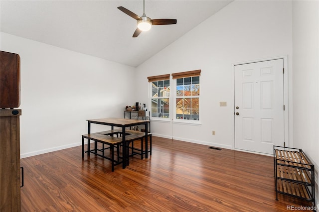 dining room with ceiling fan, dark hardwood / wood-style flooring, and high vaulted ceiling