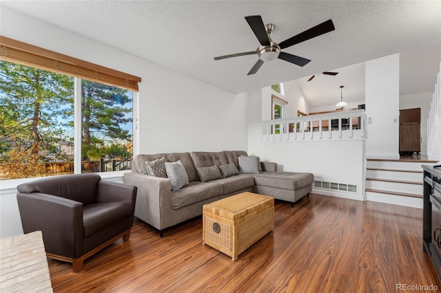 living room with a textured ceiling, ceiling fan, hardwood / wood-style floors, and vaulted ceiling