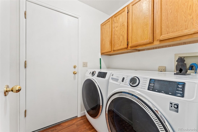 clothes washing area with separate washer and dryer, cabinets, and dark hardwood / wood-style floors