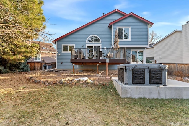 rear view of house featuring a lawn and a deck