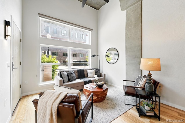 2518 16th St, Denver, CO 80211 - living room featuring wood finished floors, plenty of natural light, a high ceiling, and baseboards