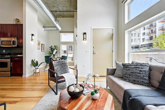 2518 16th St, Denver, CO 80211 - living area featuring a high ceiling, light wood-type flooring, and baseboards