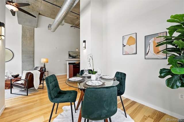 2518 16th St, Denver, CO 80211 - dining space with wood finished floors, a ceiling fan, baseboards, and a high ceiling