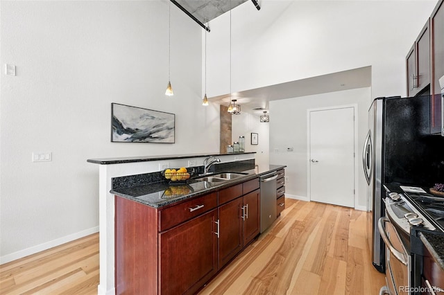 2518 16th St, Denver, CO 80211 - kitchen featuring stainless steel appliances, a sink, light wood finished floors, dark stone countertops, and a high ceiling