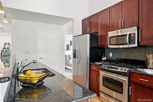 2518 16th St, Denver, CO 80211 - kitchen featuring stainless steel appliances, dark brown cabinets, a sink, backsplash, and dark stone counters