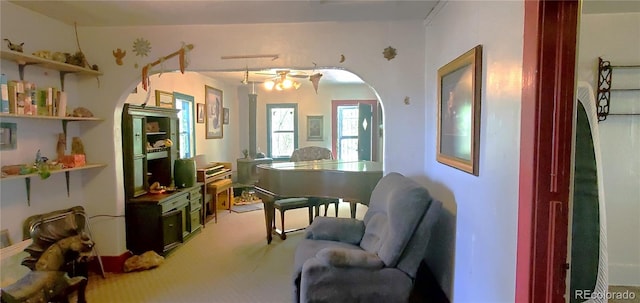 living area featuring carpet floors and ceiling fan