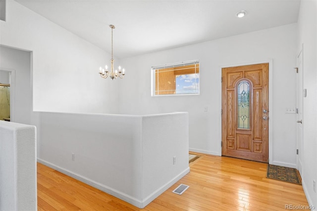 foyer featuring an inviting chandelier and light hardwood / wood-style flooring