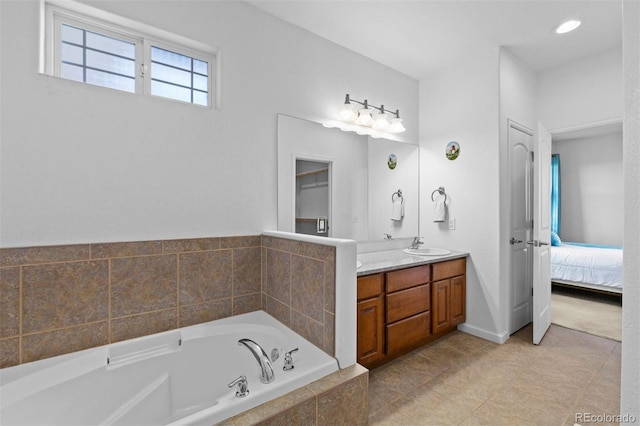 bathroom with vanity and tiled tub