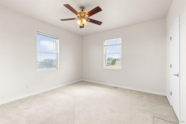 unfurnished room featuring ceiling fan, a healthy amount of sunlight, and light colored carpet