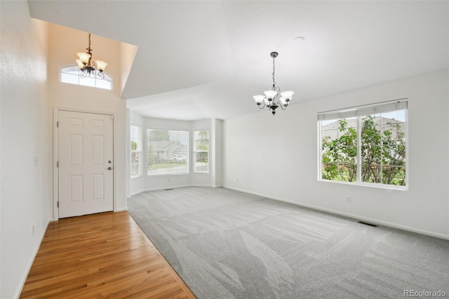 11847 Trail View Ln, Parker, CO 80134 - entrance foyer with a chandelier, a high ceiling, light colored carpet, and light wood-type flooring