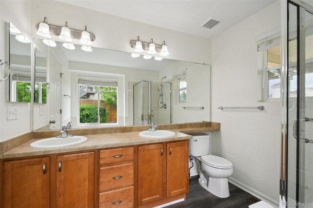 11847 Trail View Ln, Parker, CO 80134 - bathroom featuring a shower stall, double vanity, plenty of natural light, and wood finished floors