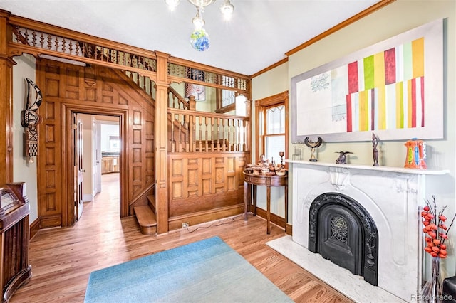 interior space featuring ornamental molding, light hardwood / wood-style floors, a premium fireplace, and plenty of natural light