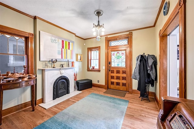 entryway featuring a notable chandelier, crown molding, and light hardwood / wood-style flooring