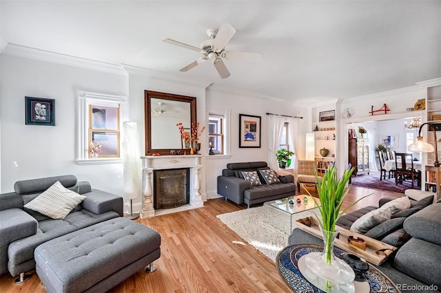 living room featuring light hardwood / wood-style flooring, ornamental molding, and ceiling fan