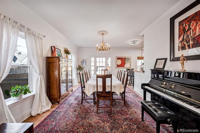 dining space featuring hardwood / wood-style flooring, ornamental molding, and an inviting chandelier