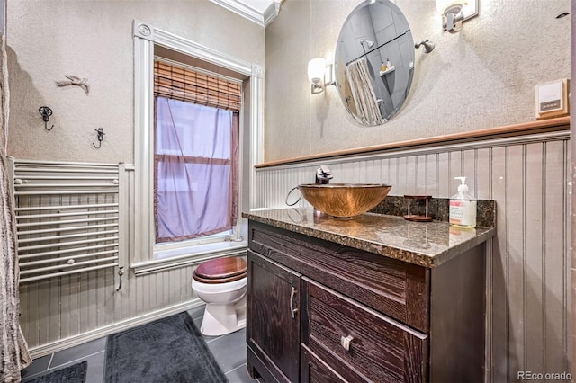 bathroom with vanity, radiator, tile patterned flooring, and toilet