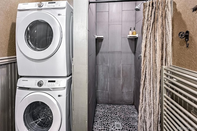 clothes washing area with radiator and stacked washer and clothes dryer