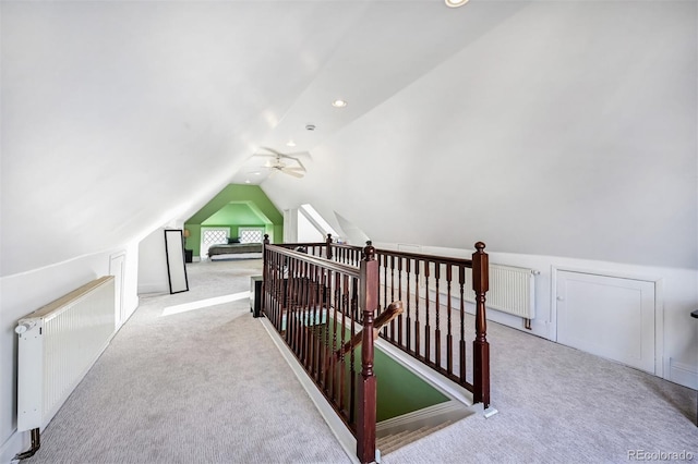 bonus room with light carpet, radiator, lofted ceiling, and ceiling fan