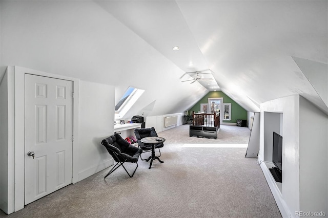 sitting room featuring vaulted ceiling with skylight, light carpet, and ceiling fan