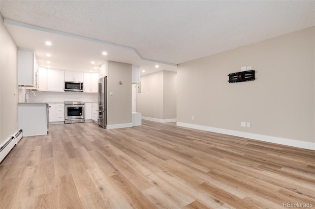 unfurnished living room with a textured ceiling, light hardwood / wood-style floors, and sink