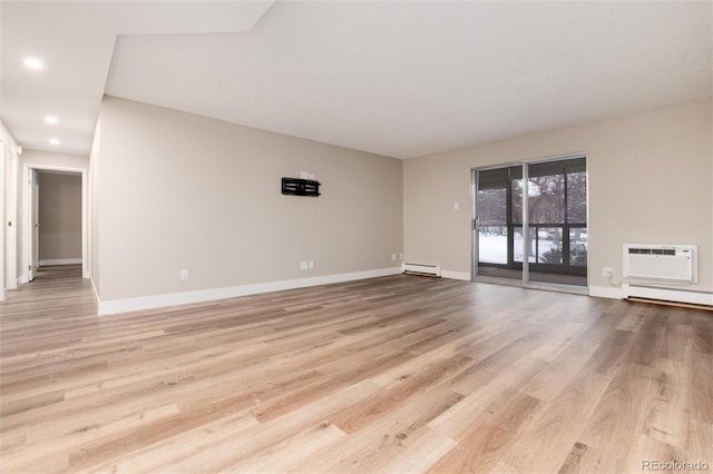 unfurnished room with light hardwood / wood-style floors, a baseboard radiator, and a wall mounted AC