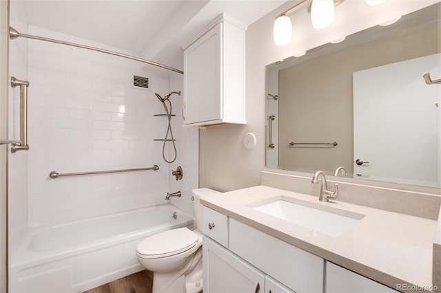 full bathroom with vanity, hardwood / wood-style floors, tiled shower / bath combo, and toilet