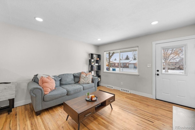 living room featuring a textured ceiling and light hardwood / wood-style flooring