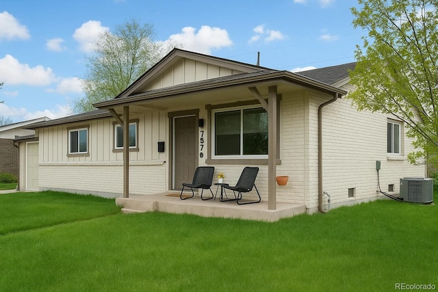 757 S Wheeling St, Aurora, CO 80012 - rear view of property featuring brick siding, board and batten siding, a porch, cooling unit, and a lawn