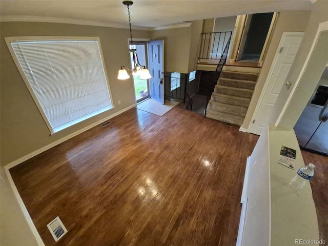 1962 S Ivory Way, Aurora, CO 80013 - unfurnished dining area featuring dark wood finished floors, stairs, ornamental molding, baseboards, and a chandelier