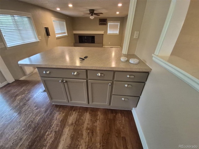 1962 S Ivory Way, Aurora, CO 80013 - kitchen featuring gray cabinets, a ceiling fan, dark wood-type flooring, a fireplace with raised hearth, and recessed lighting
