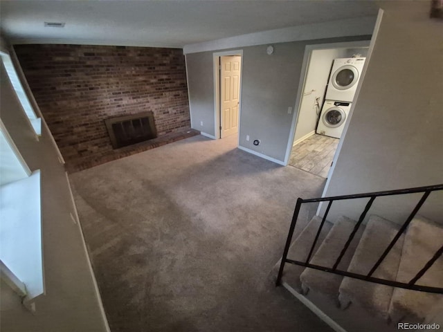 1962 S Ivory Way, Aurora, CO 80013 - unfurnished living room with estacked washer and dryer, carpet flooring, and baseboards