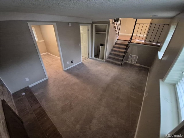1962 S Ivory Way, Aurora, CO 80013 - unfurnished living room featuring stairs, baseboards, a textured ceiling, and carpet floors