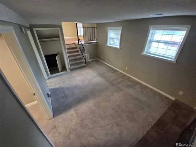 1962 S Ivory Way, Aurora, CO 80013 - unfurnished living room with stairs, baseboards, and carpet flooring