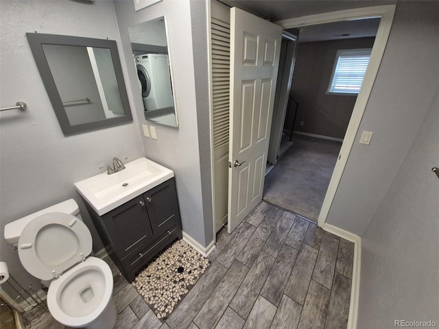 1962 S Ivory Way, Aurora, CO 80013 - bathroom with vanity, wood finished floors, toilet, baseboards, and washer / clothes dryer