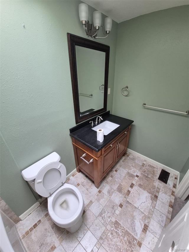 1962 S Ivory Way, Aurora, CO 80013 - bathroom with vanity, toilet, baseboards, and a chandelier