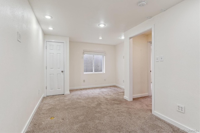 carpeted spare room featuring baseboards and recessed lighting