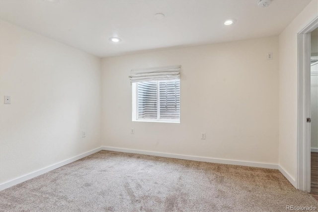 carpeted empty room featuring baseboards and recessed lighting