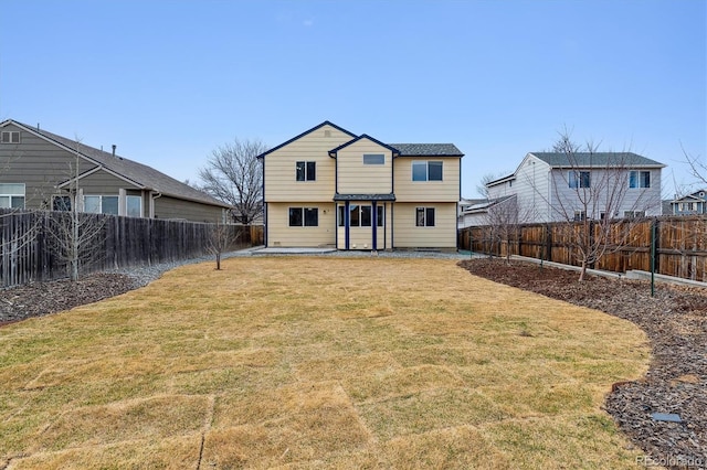 back of property with a patio, a fenced backyard, and a yard