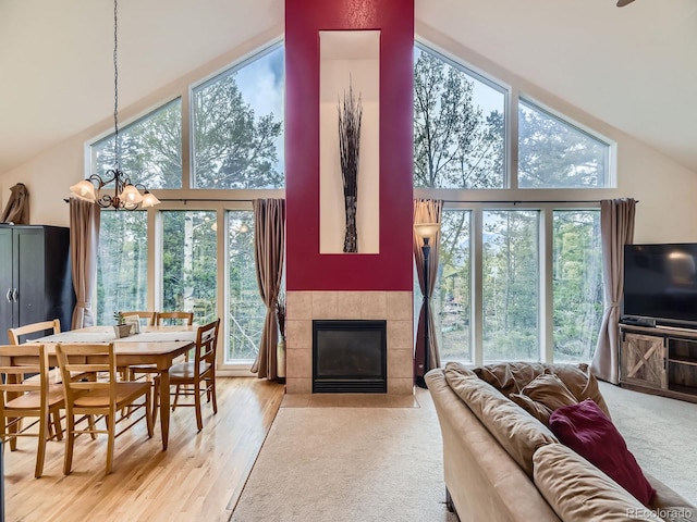11526 Green Cir, Conifer, CO 80433 - living room with a chandelier, a tiled fireplace, high vaulted ceiling, and wood finished floors