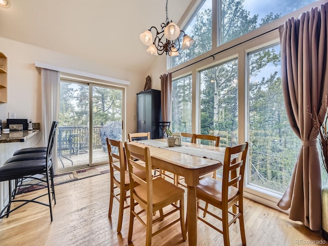 11526 Green Cir, Conifer, CO 80433 - dining area with light wood finished floors, a chandelier, and vaulted ceiling