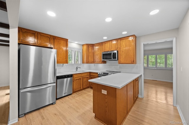 888 E Davies Ave, Centennial, CO 80122 - kitchen with stainless steel appliances, a peninsula, light wood-style flooring, tasteful backsplash, and recessed lighting