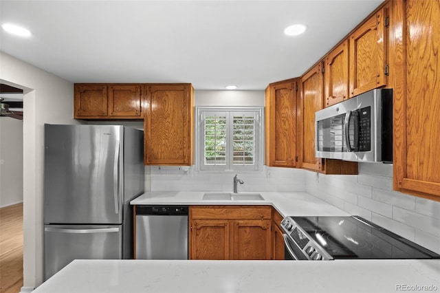 888 E Davies Ave, Centennial, CO 80122 - kitchen with stainless steel appliances, backsplash, brown cabinets, and recessed lighting
