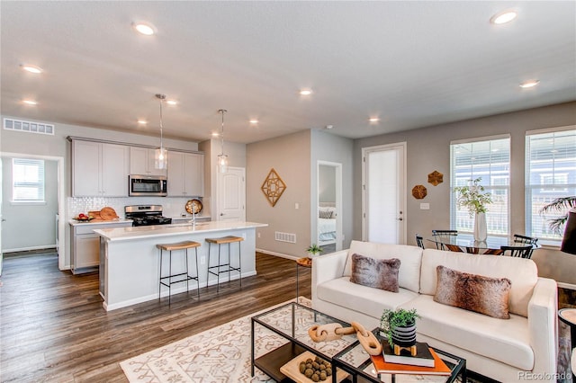 living room featuring visible vents, recessed lighting, baseboards, and dark wood-style flooring