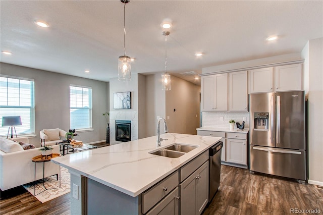 kitchen featuring a sink, stainless steel fridge with ice dispenser, open floor plan, dishwashing machine, and dark wood-type flooring