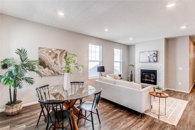 living room with baseboards, recessed lighting, wood finished floors, and a tile fireplace
