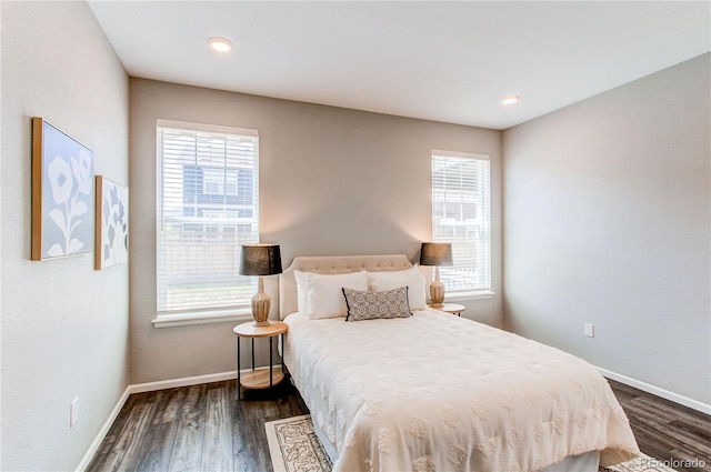 bedroom with dark wood-style flooring and multiple windows